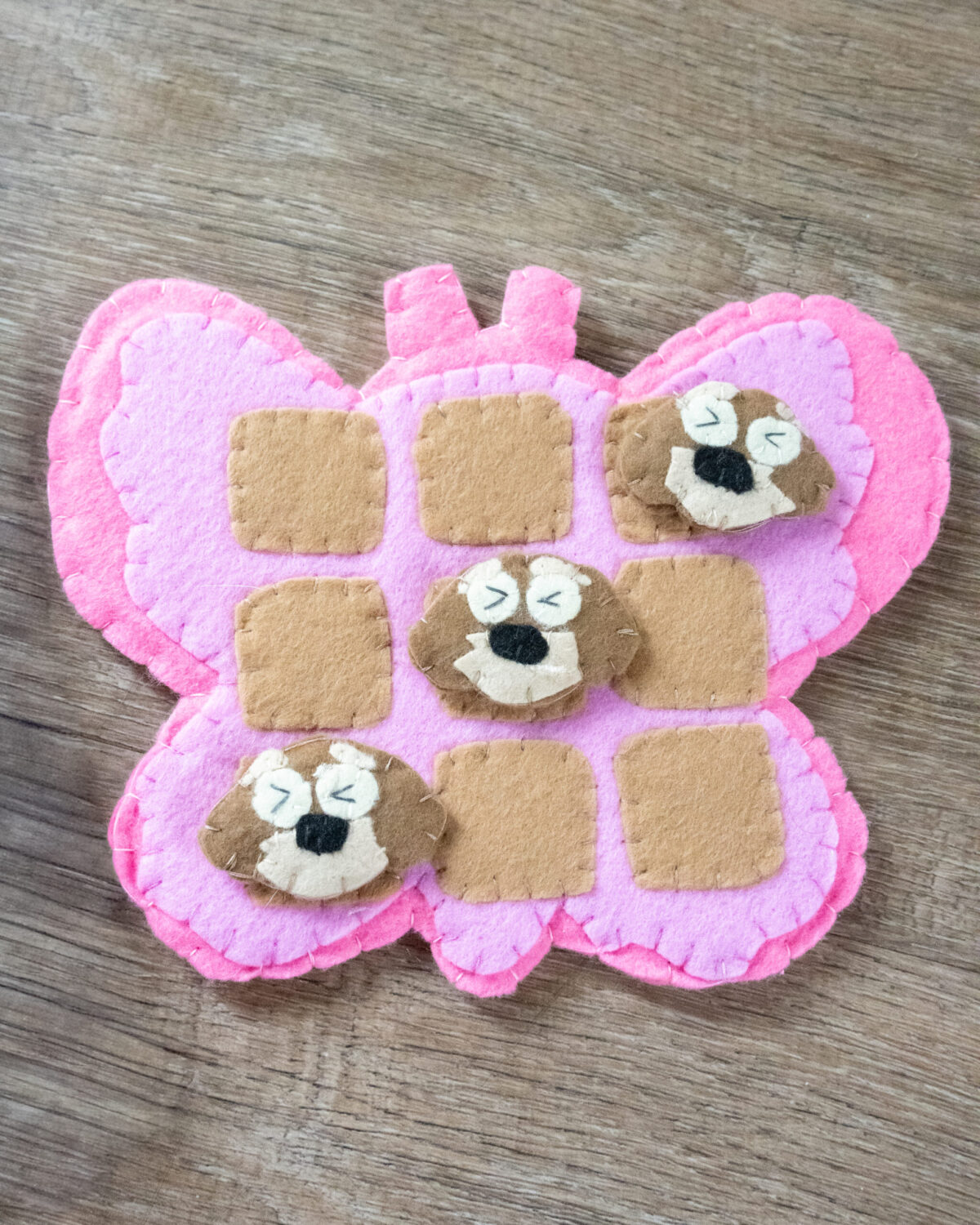 Handmade felt Tic Tac Toe board game with dog and bee pieces, eco-friendly and perfect for kids’ sensory and mindfulness play.